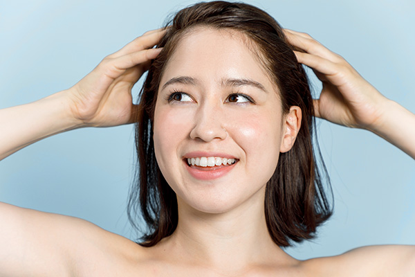 girl doing daily scalp massage to reduce hair loss